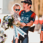 Cyclist on podium holding child