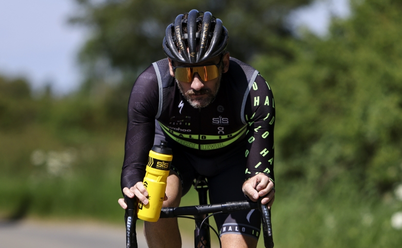 Tim Don fait du vélo avec une bouteille d'eau à la main