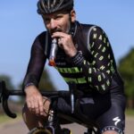 Tim Don comiendo una barrita de proteínas en la bici