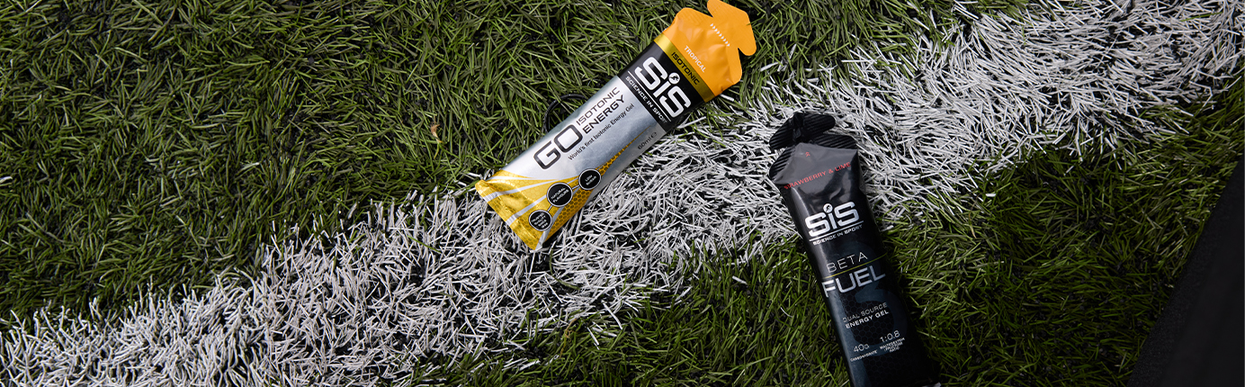 SiS GO Isotonic Energy Gel and a BETA Fuel Dual-Source Energy Gel on a pitch