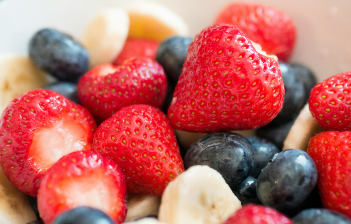 Un bol de fruits parfaits pour l'alimentation des sportifs : des fraises, des myrtilles et des bananes. 