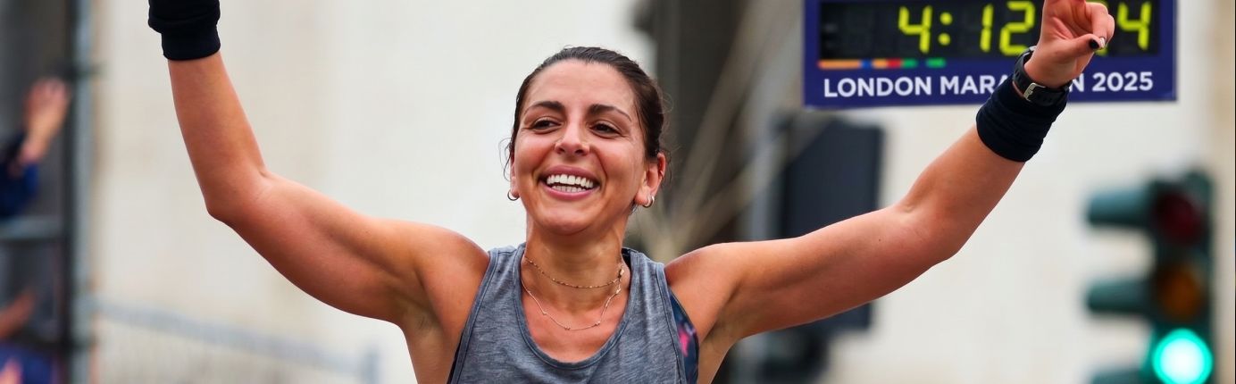 A female runner crossing the finish line at the London Marathon