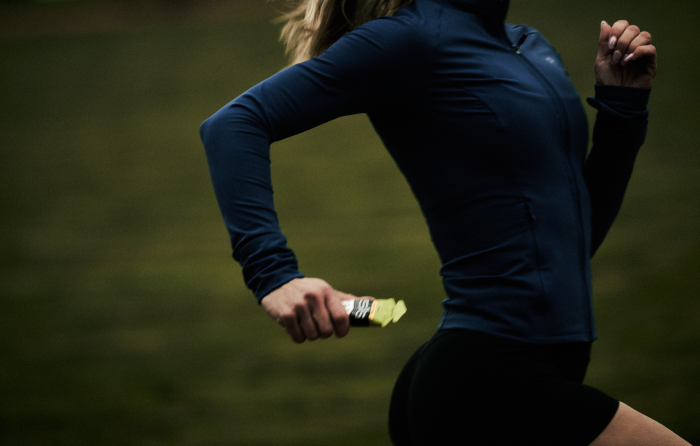 Runner holding a SiS GO Isotonic+Electrolyte Gel in apple flavour