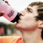 Athlete drinking an electrolyte solution from a SiS water bottle