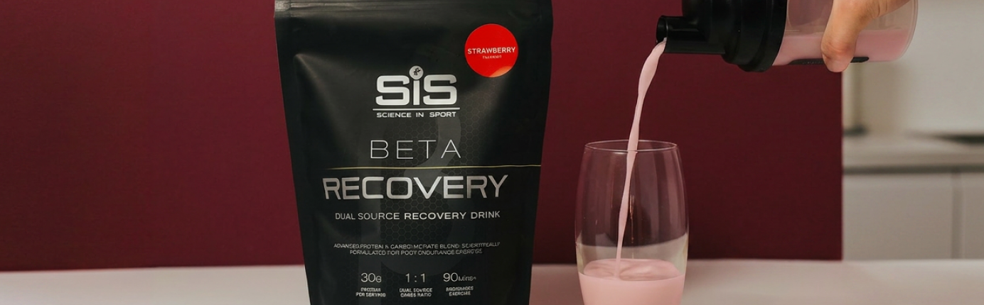 BETA Recovery Shake being poured into a glass with a bag of BETA Recovery next to it