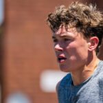 Close-up of a runner's strained, sweaty face against a brick wall backdrop