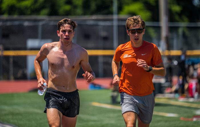 Deux coureurs côte à côte, l'un torse nu et complètement trempé de sueur, l'autre qui n'a pas l'air de s'en soucier
