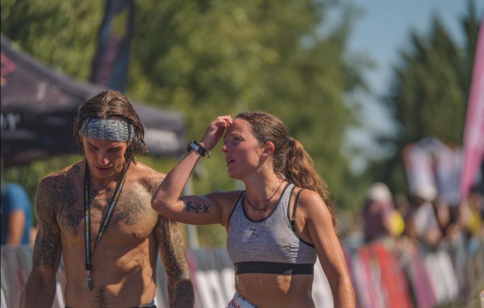 two sweat-drenched athletes walking together after finishing a session.