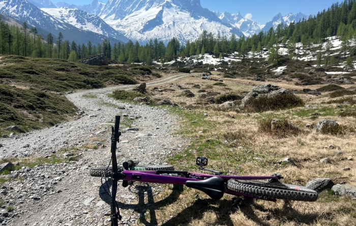 Un vélo posé à l'horizontale devant une vue sur le Mont Blanc